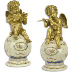 A PAIR OF BRONZE PUTTI ON PORCELAIN BALL