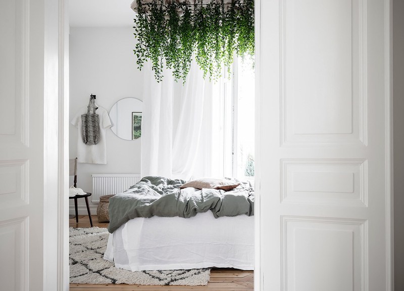 Zien: bijzondere slaapkamer met hangplanten boven het bed