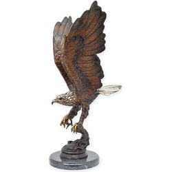 A BRONZE SCULPTURE OF AN EAGLE FISHING FOR SALMON