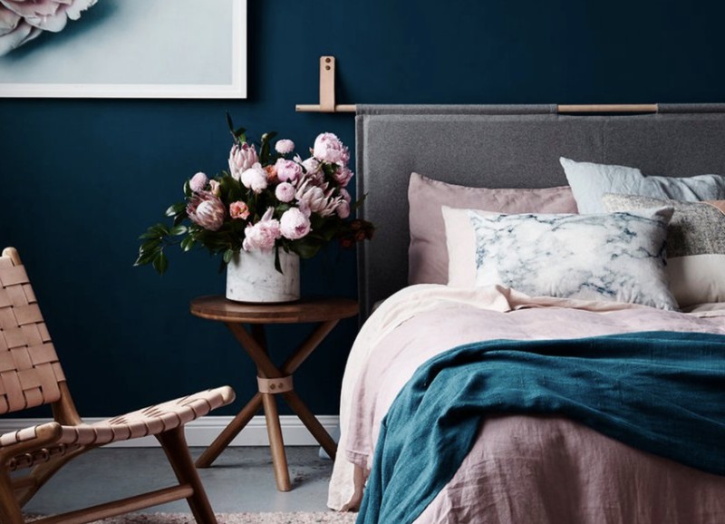 Een donkerblauwe muur in de slaapkamer, welke kleuren passen daarbij?
