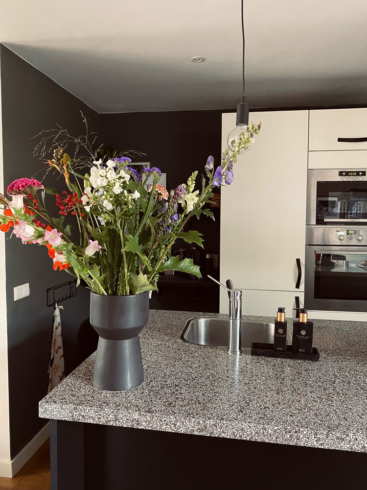 zwarte vaas met bloemen in keuken