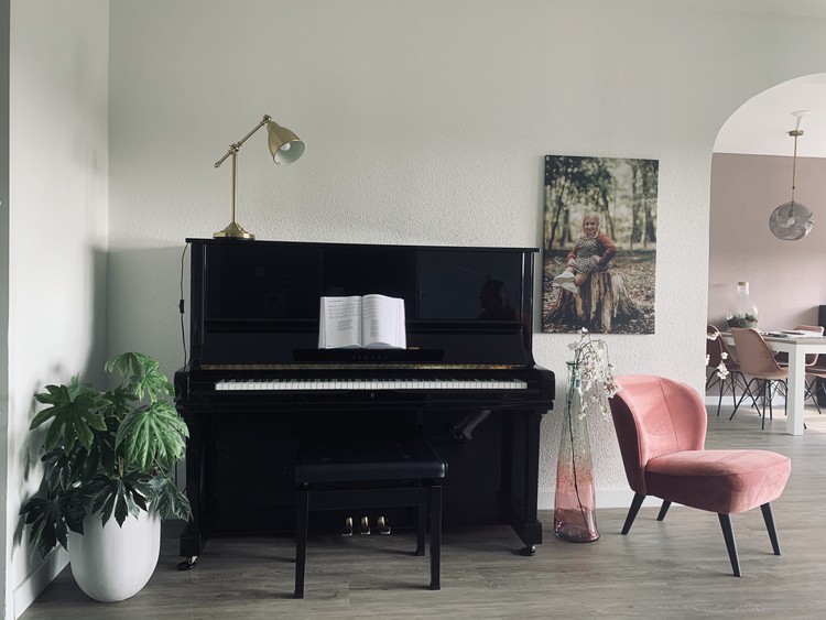 wand met piano en roze fauteuil