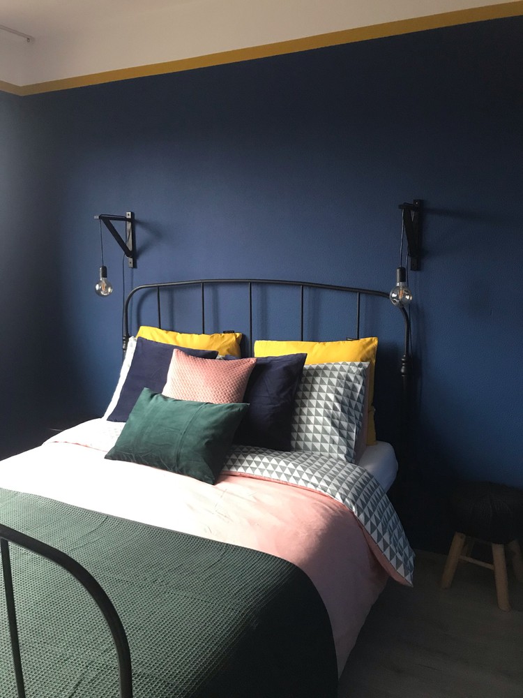 Donkerblauwe slaapkamer met felle kleuren