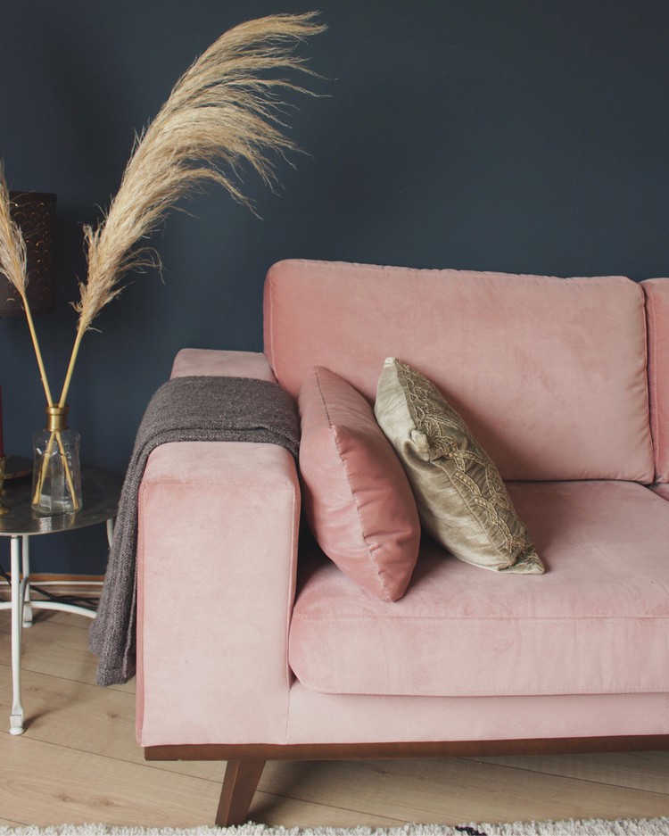 roze bank tegen blauwe muur