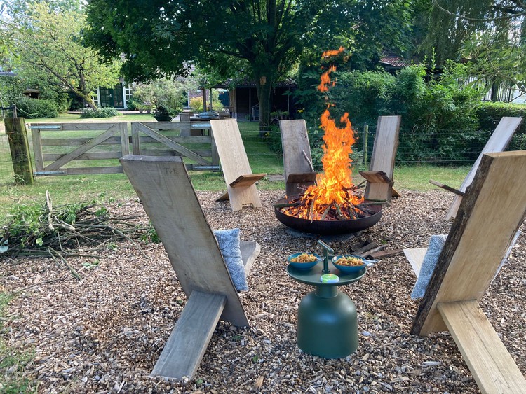 vuurkorf-met-houten-tuinstoelen